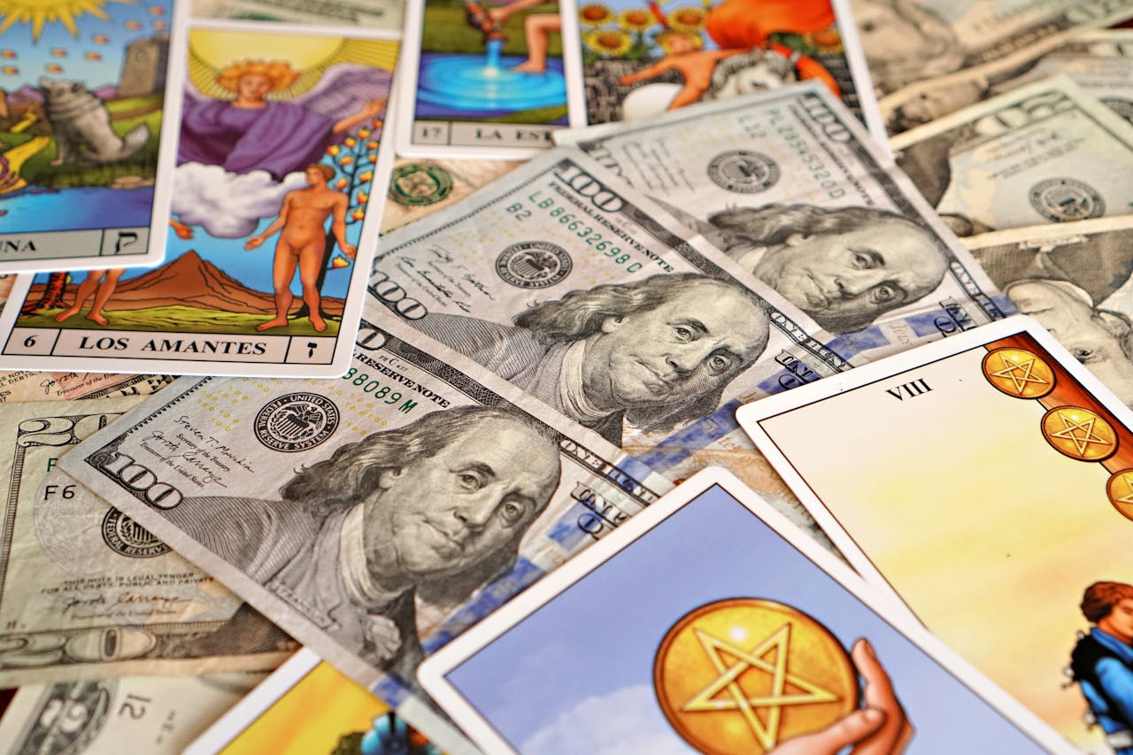 Vibrant tarot cards and US dollar bills create a mystic and affluent flat lay composition.